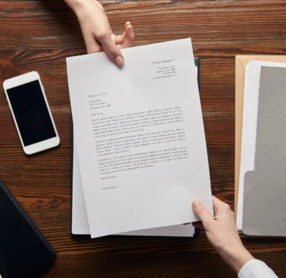 VistaCreate-247536370-stock-photo-top-view-businesspeople-holding-contract-workplace-copy-space